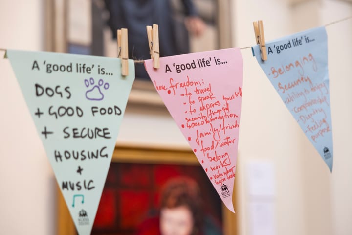 Colourful triangular flags with writing one them "A 'good life' is..."